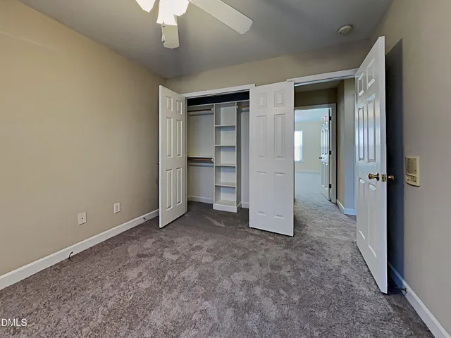 an empty room with closet and windows