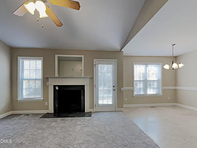wooden floor fireplace and windows in an empty room