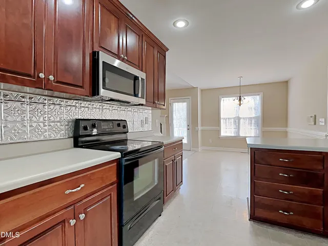 a kitchen with stainless steel appliances granite countertop wooden cabinets and a stove top oven
