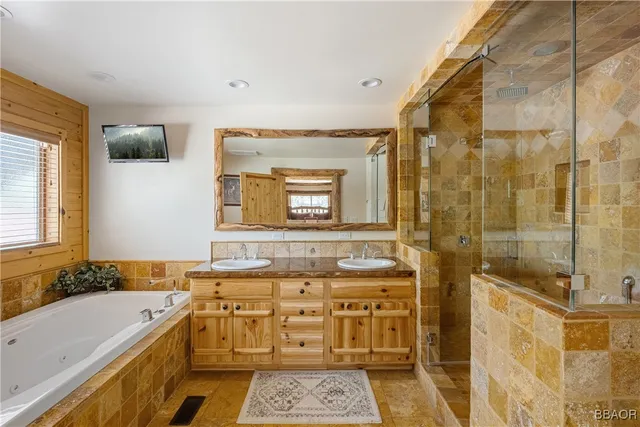 a bathroom with a granite countertop sink a mirror a and a shower