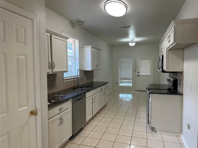 a kitchen with stainless steel appliances granite countertop a sink and cabinets