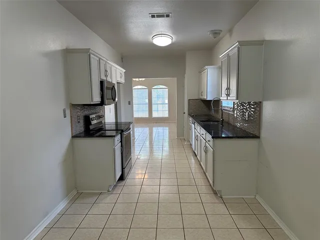 a kitchen with stainless steel appliances a sink stove and cabinets
