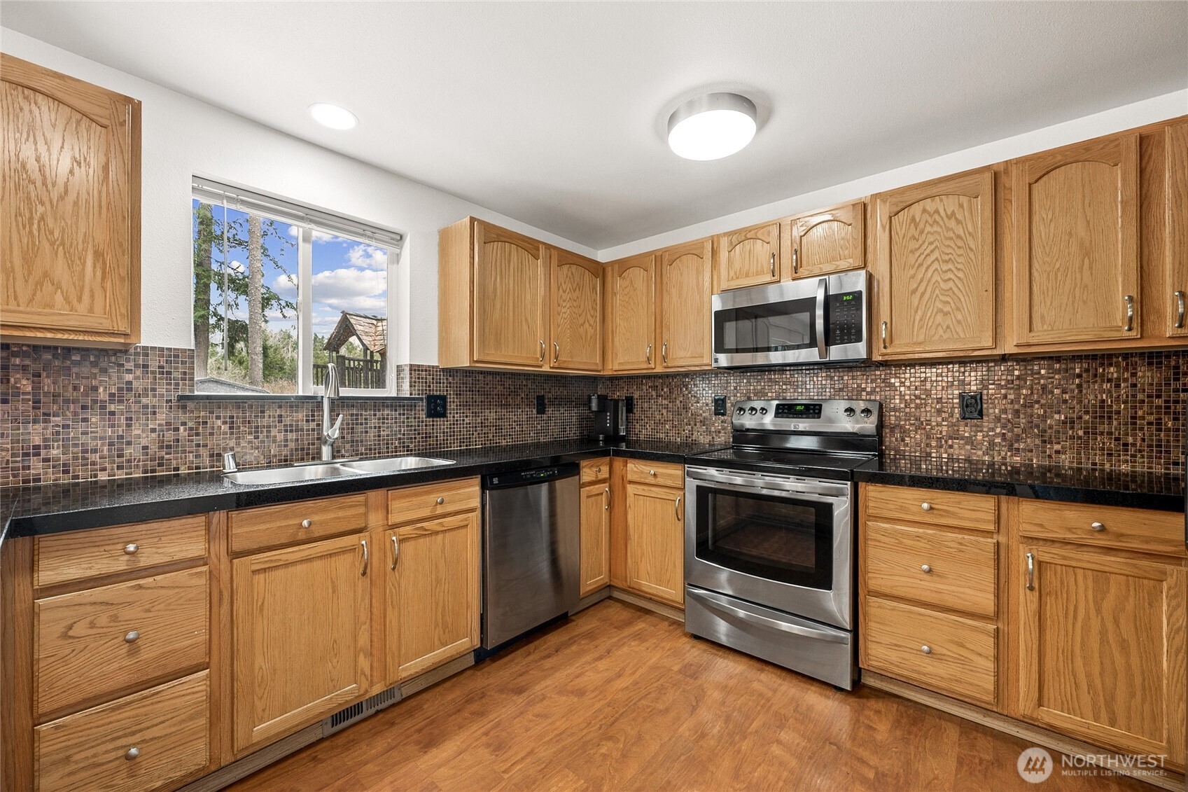 17535 Loop Lane Southeast Yelm, WA 98597 - Photo 15 of 30 a kitchen with granite countertop a sink cabinets stainless steel appliances and a window