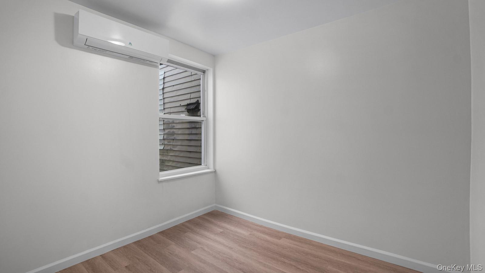 681 Rhinelander Avenue Bronx, NY 10462 - Photo 11 of 30 Unfurnished room with light wood finished floors and an AC wall unit