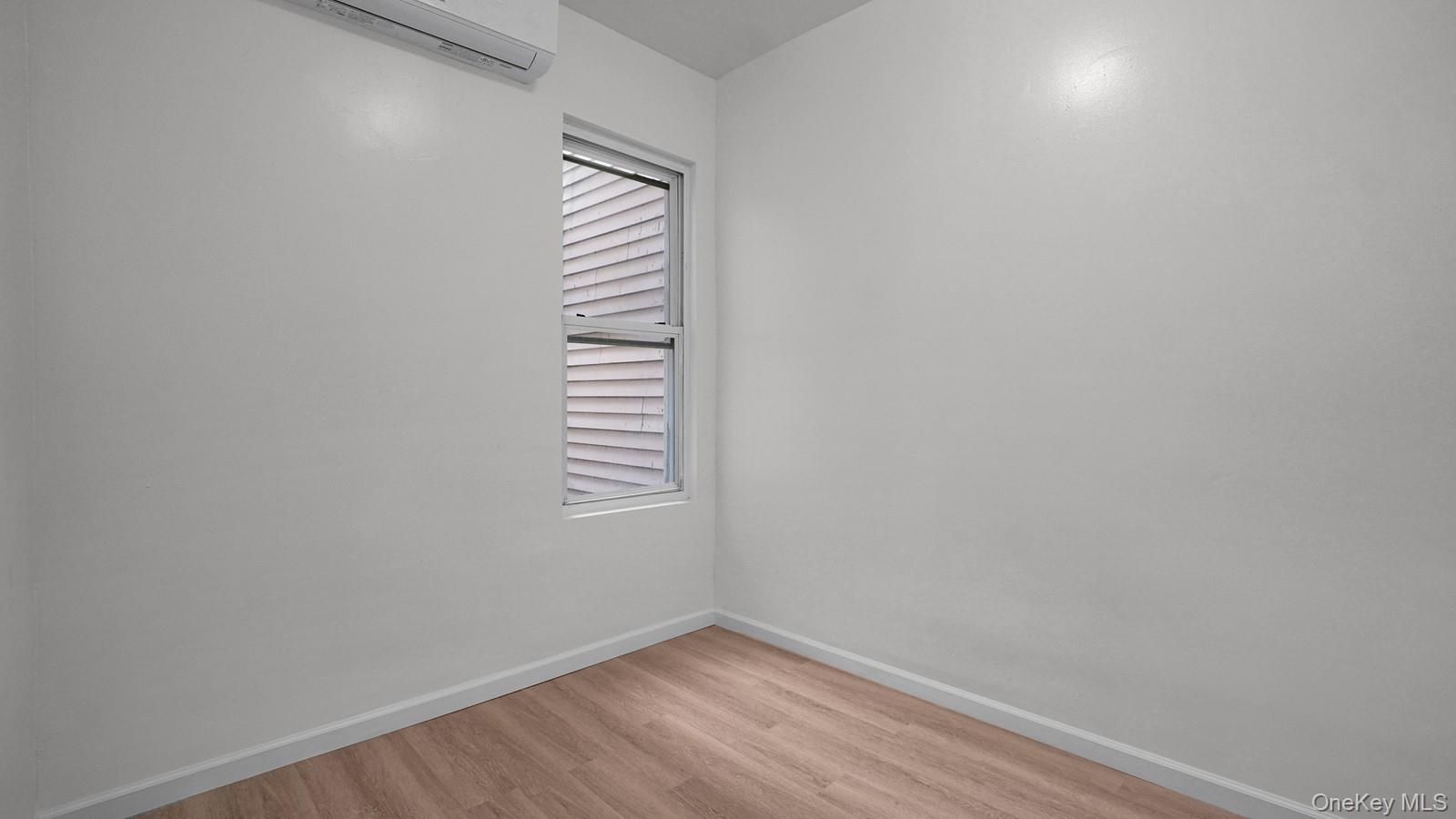 681 Rhinelander Avenue Bronx, NY 10462 - Photo 15 of 30 Unfurnished room with light wood-style floors and an AC wall unit