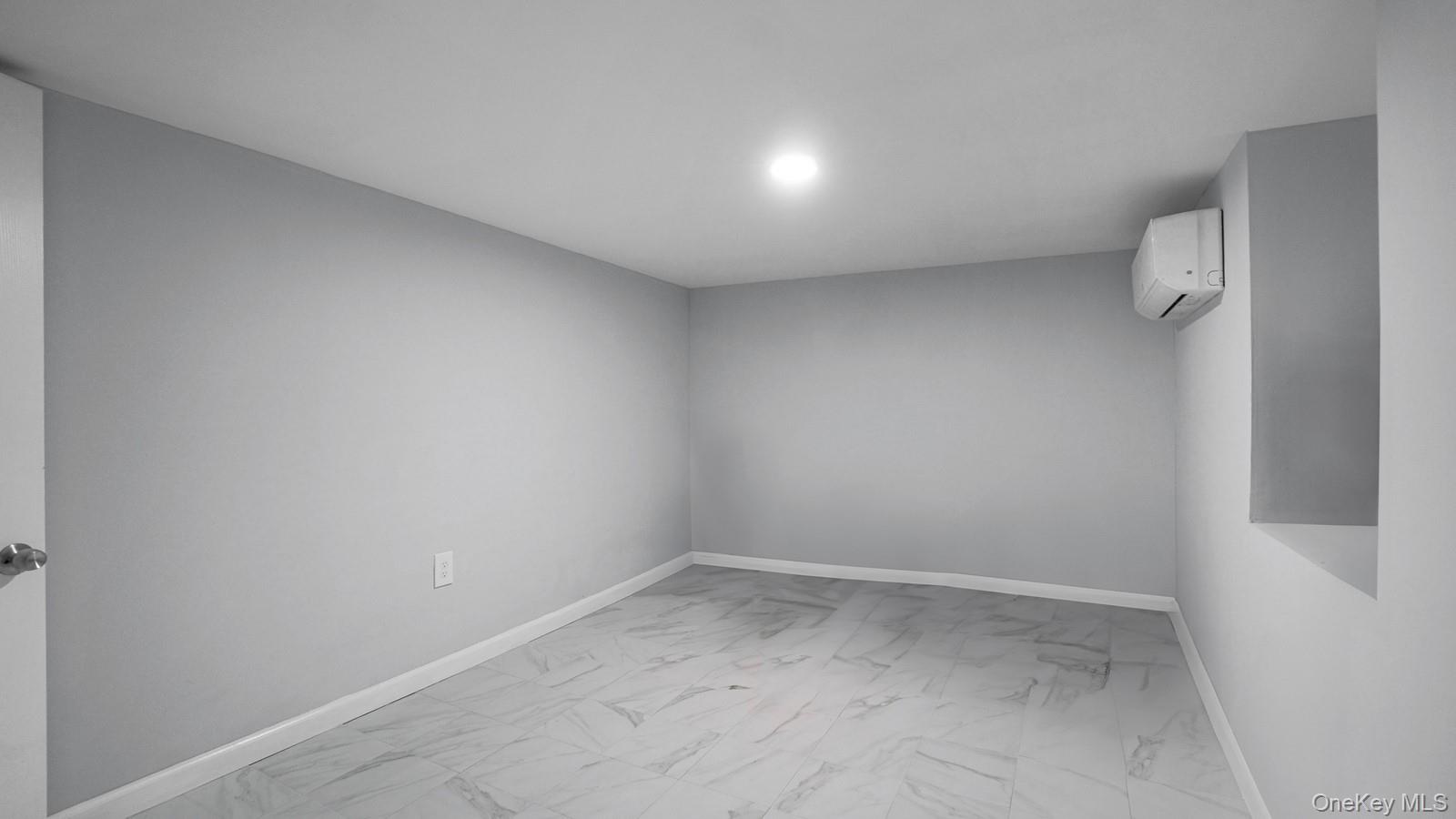 681 Rhinelander Avenue Bronx, NY 10462 - Photo 20 of 30 Spare room featuring light marble finish flooring and a wall unit AC