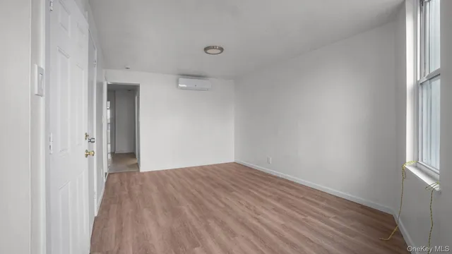 a view of a room with wooden floor and a window