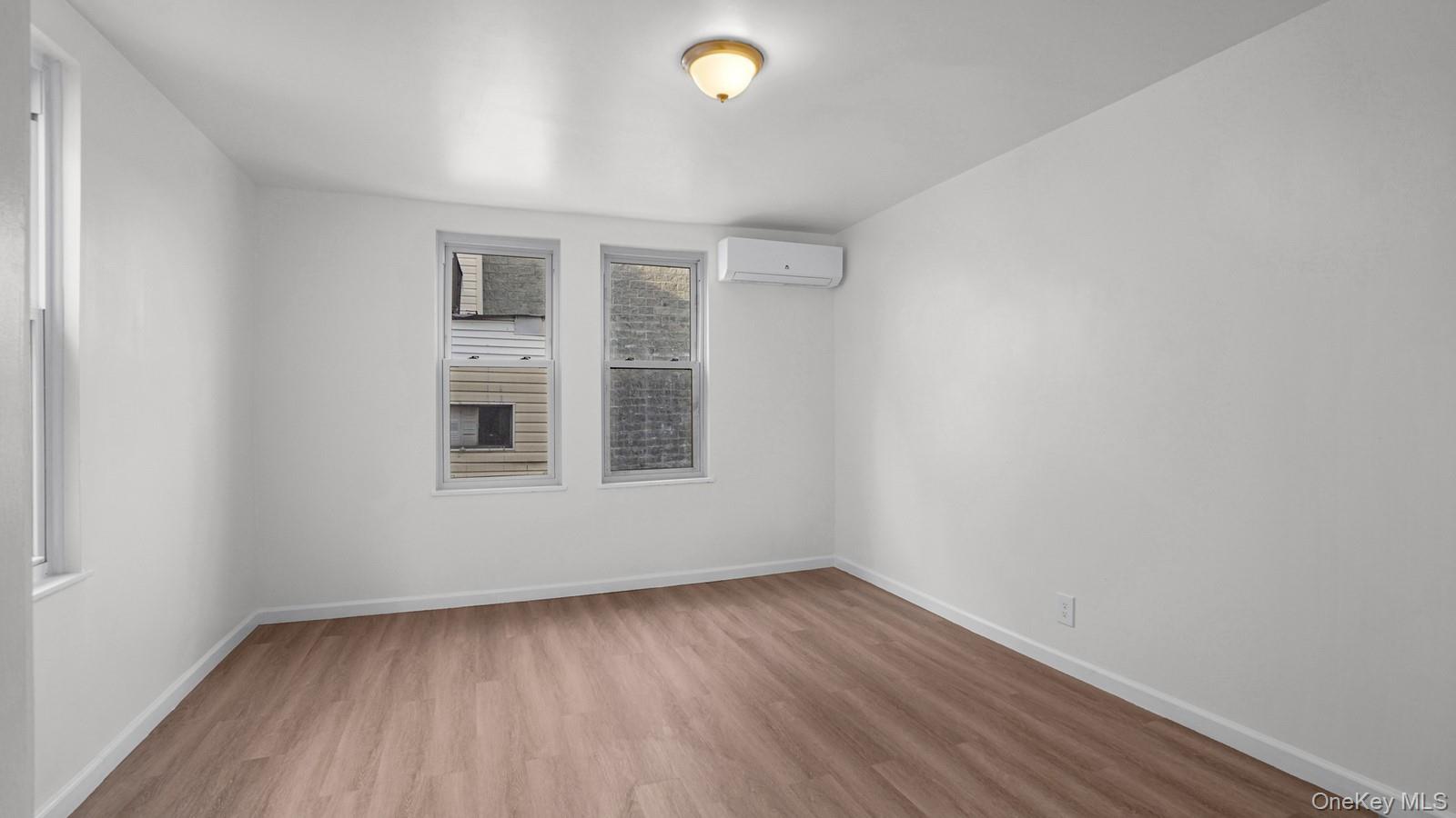 681 Rhinelander Avenue Bronx, NY 10462 - Photo 10 of 30 Spare room with light wood-style flooring and a wall mounted AC