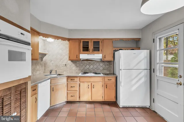 a kitchen with granite countertop cabinets stainless steel appliances a sink and a window