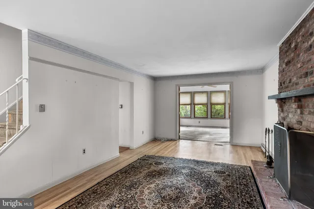 a view of a livingroom with wooden floor and a fireplace
