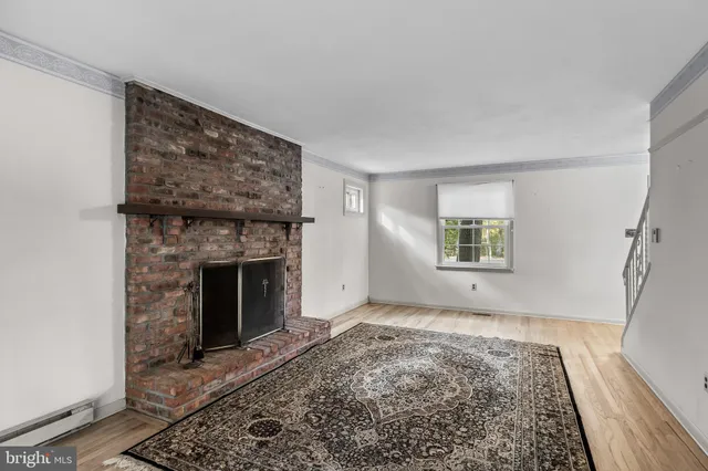 a view of a livingroom with wooden floor and a fireplace