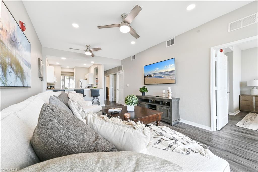 7915 Mahogany Run Lane, Unit 1115 Naples, FL 34113 - Photo 12 of 39 a living room with furniture kitchen view and a wooden floor