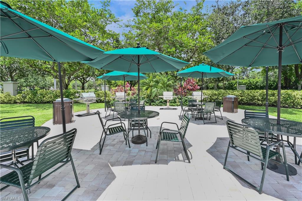 7915 Mahogany Run Lane, Unit 1115 Naples, FL 34113 - Photo 17 of 39 an outdoor space with patio and white umbrellas