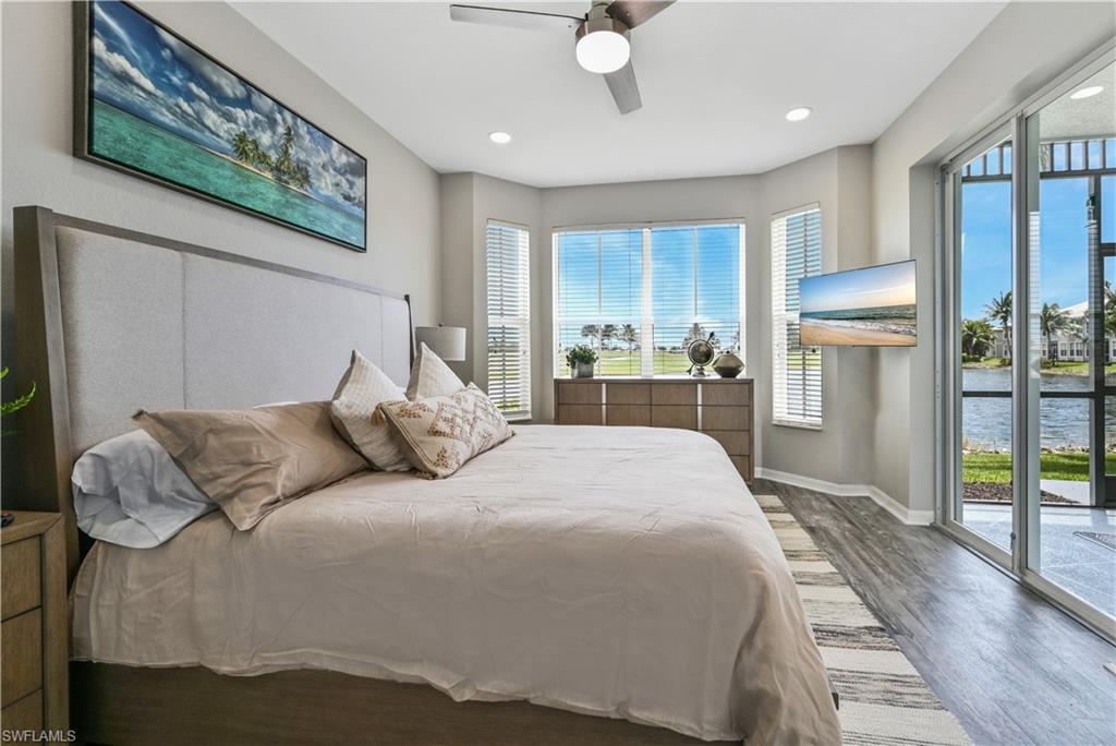 7915 Mahogany Run Lane, Unit 1115 Naples, FL 34113 - Photo 33 of 39 a bedroom with a large bed and a chandelier