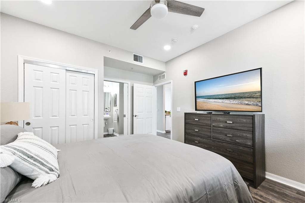7915 Mahogany Run Lane, Unit 1115 Naples, FL 34113 - Photo 35 of 39 a bedroom with a bed and a flat screen tv