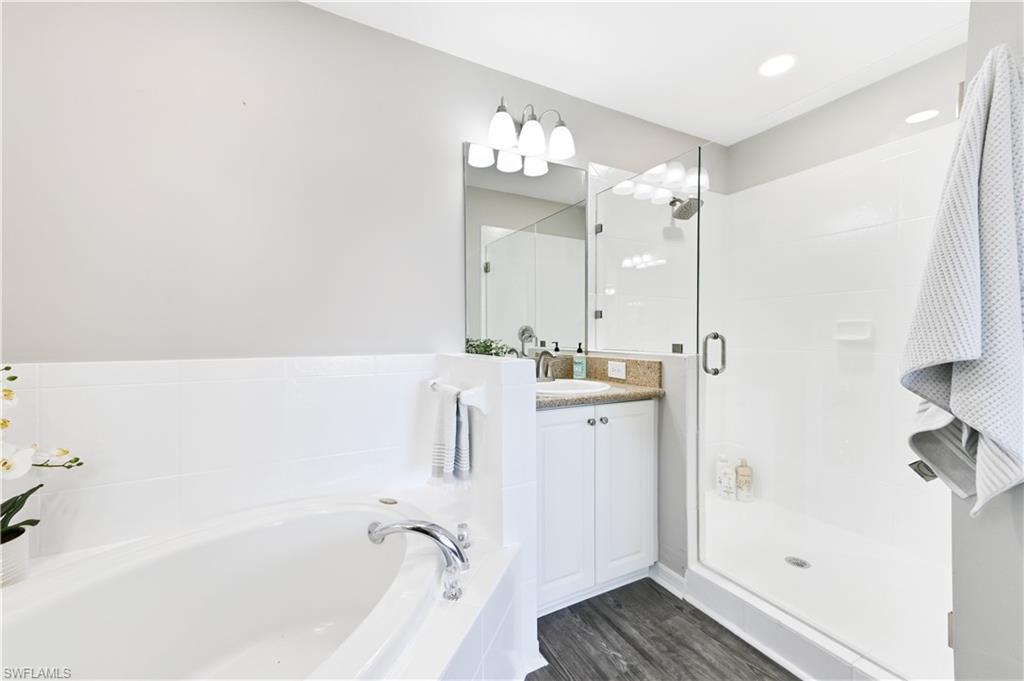 7915 Mahogany Run Lane, Unit 1115 Naples, FL 34113 - Photo 39 of 39 a bathroom with a tub sink and mirror