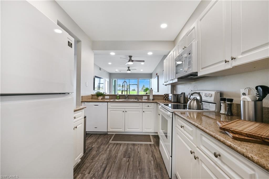 7915 Mahogany Run Lane, Unit 1115 Naples, FL 34113 - Photo 10 of 39 a kitchen with granite countertop cabinets stainless steel appliances and a counter space
