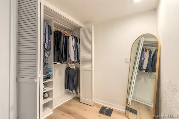a view of walk in closet with clothes and shoes