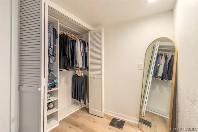 a view of walk in closet with clothes and shoes