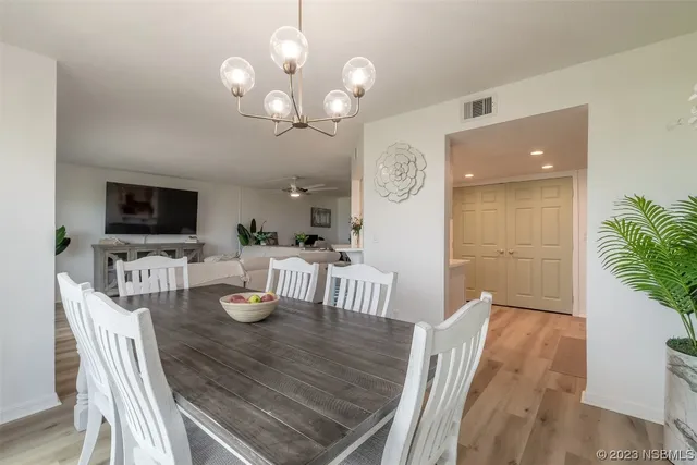 a view of a dining room with furniture a chandelier and wooden floor