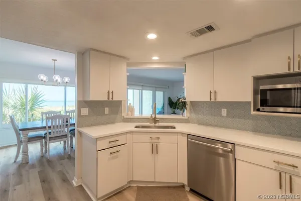 a kitchen with white cabinets and appliances
