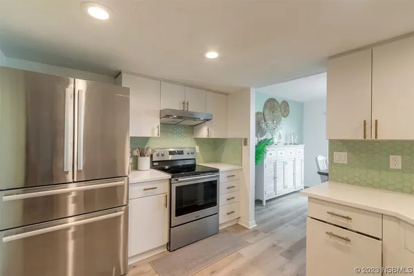 a kitchen with stainless steel appliances a refrigerator sink and stove