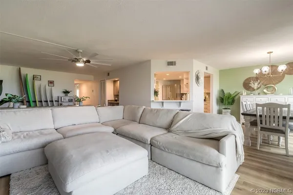 a living room with furniture and a large mirror with wooden floor