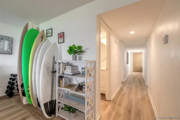 a view of a hallway with workspace and living room