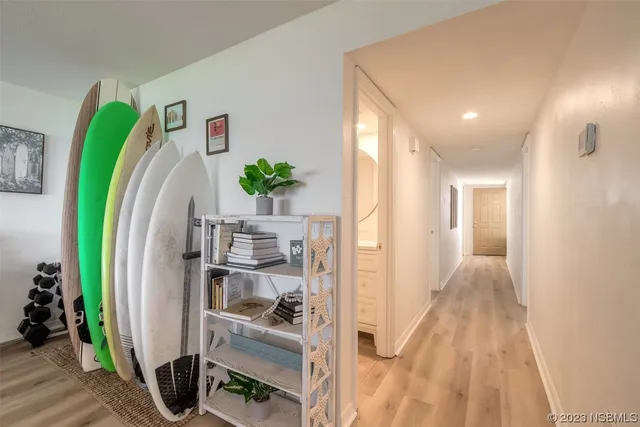 a view of a hallway with workspace and living room