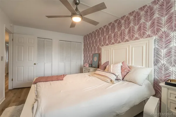 a bedroom with a large bed and a chandelier