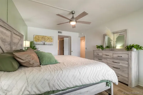 a bedroom with a large bed and a chandelier