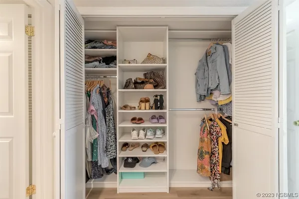 a view of walk in closet with clothes and shoes