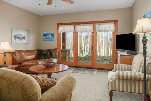 a living room with furniture a ceiling fan and a window