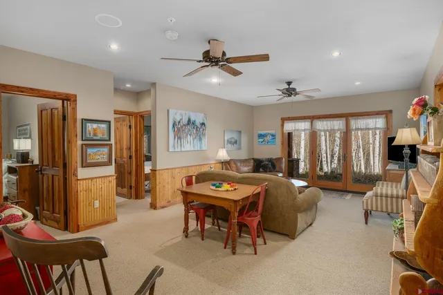a living room with furniture kitchen and a chandelier