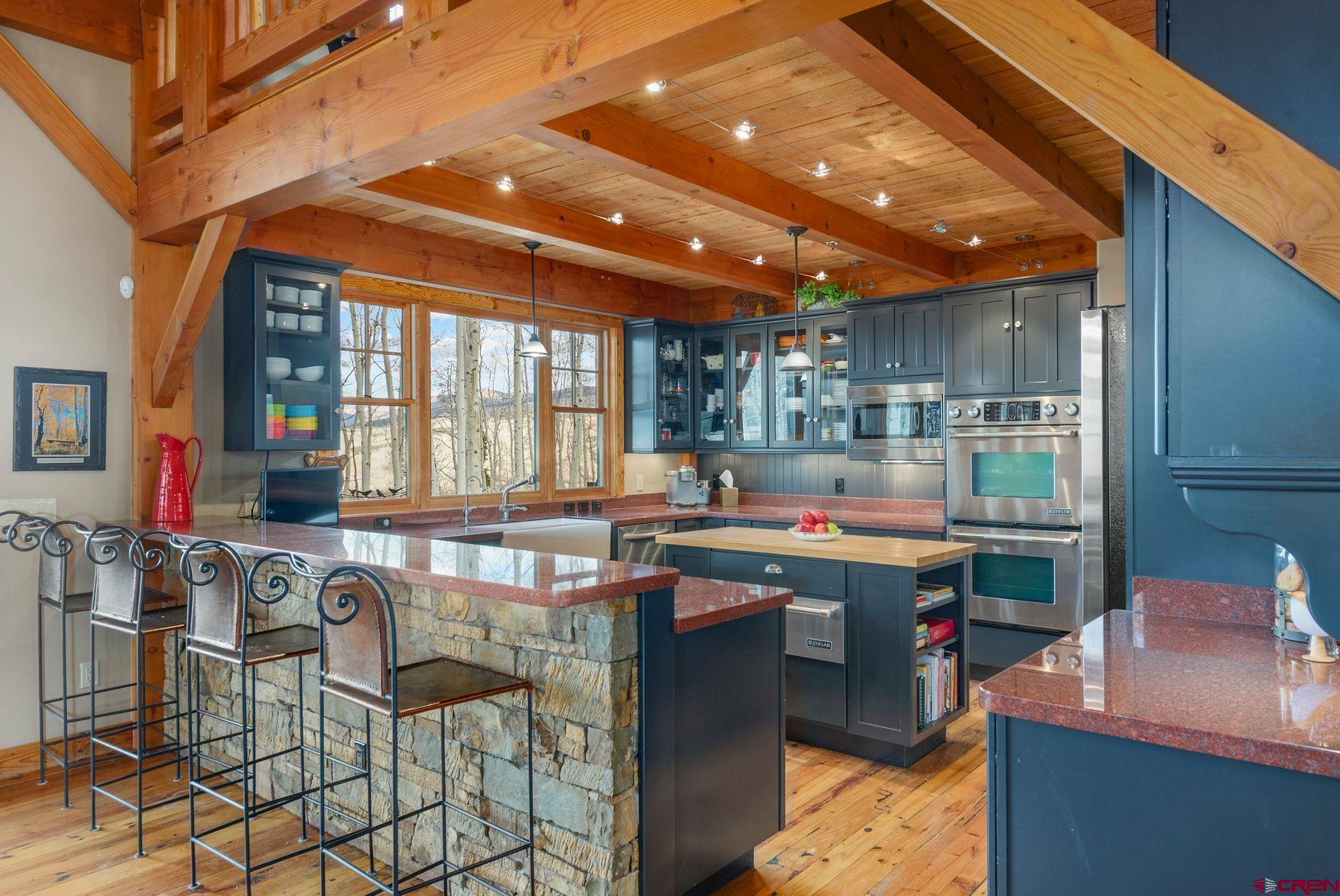 796 Red Mountain Ranch Road Crested Butte, CO 81224 - Photo 6 of 45 a kitchen with kitchen island granite countertop a sink and counter space