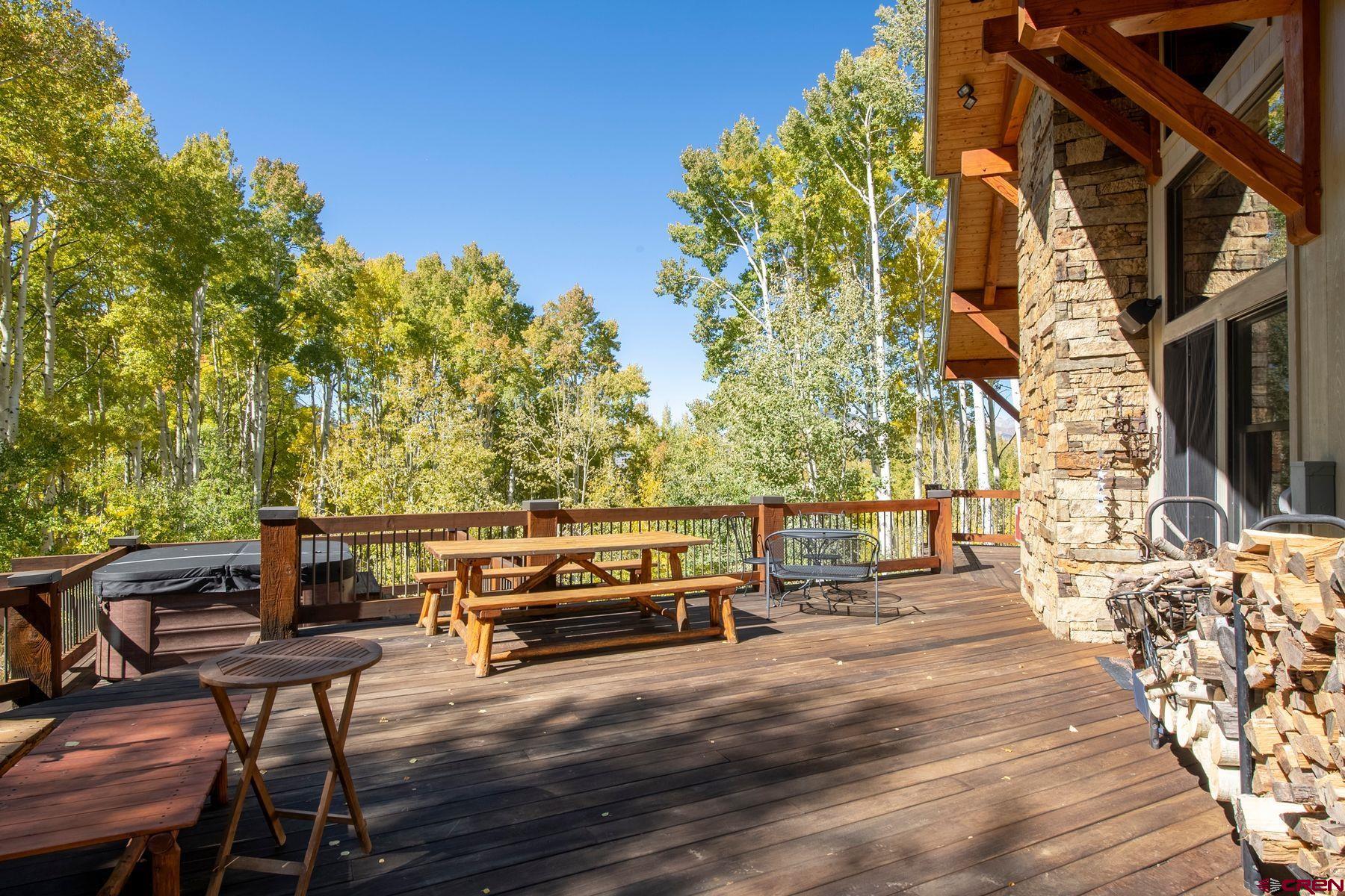 796 Red Mountain Ranch Road Crested Butte, CO 81224 - Photo 9 of 45 a view of a patio with table and chairs and couches with wooden floor and fence