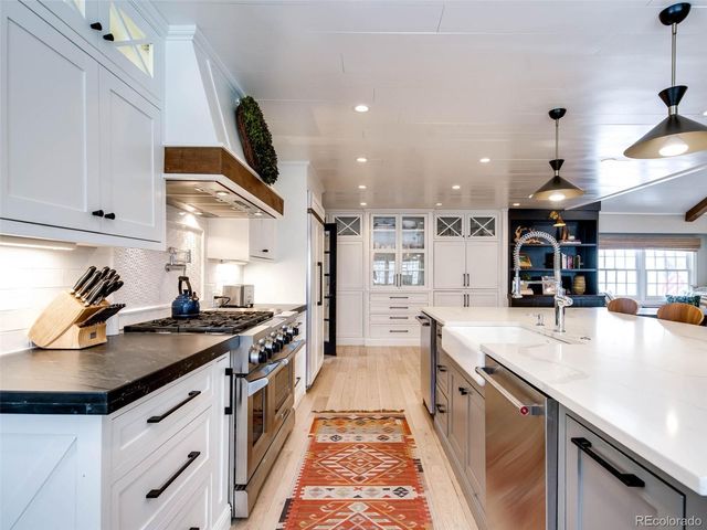 a kitchen with stainless steel appliances granite countertop a lot of counter space and wooden floors