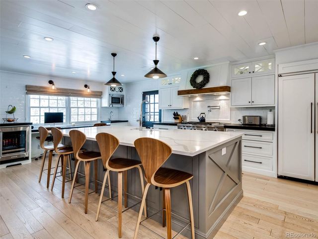 a kitchen with stainless steel appliances granite countertop a stove a sink a dining table and chairs