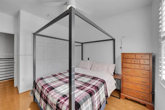 a bedroom with a bed and wooden floor