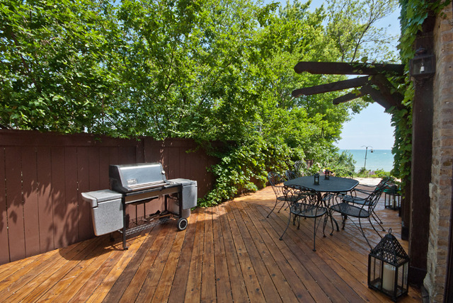 337 Sheridan Road Winnetka, IL 60093 - Photo 25 of 25 a backyard of a house with table and chairs wooden floor and a large tree