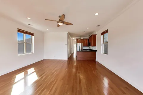 a view of empty room with wooden floor and windows