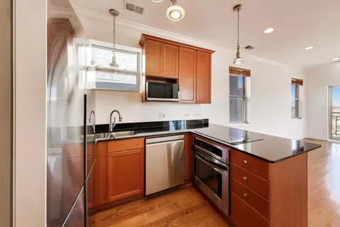 a kitchen with stainless steel appliances granite countertop a sink a stove and a refrigerator
