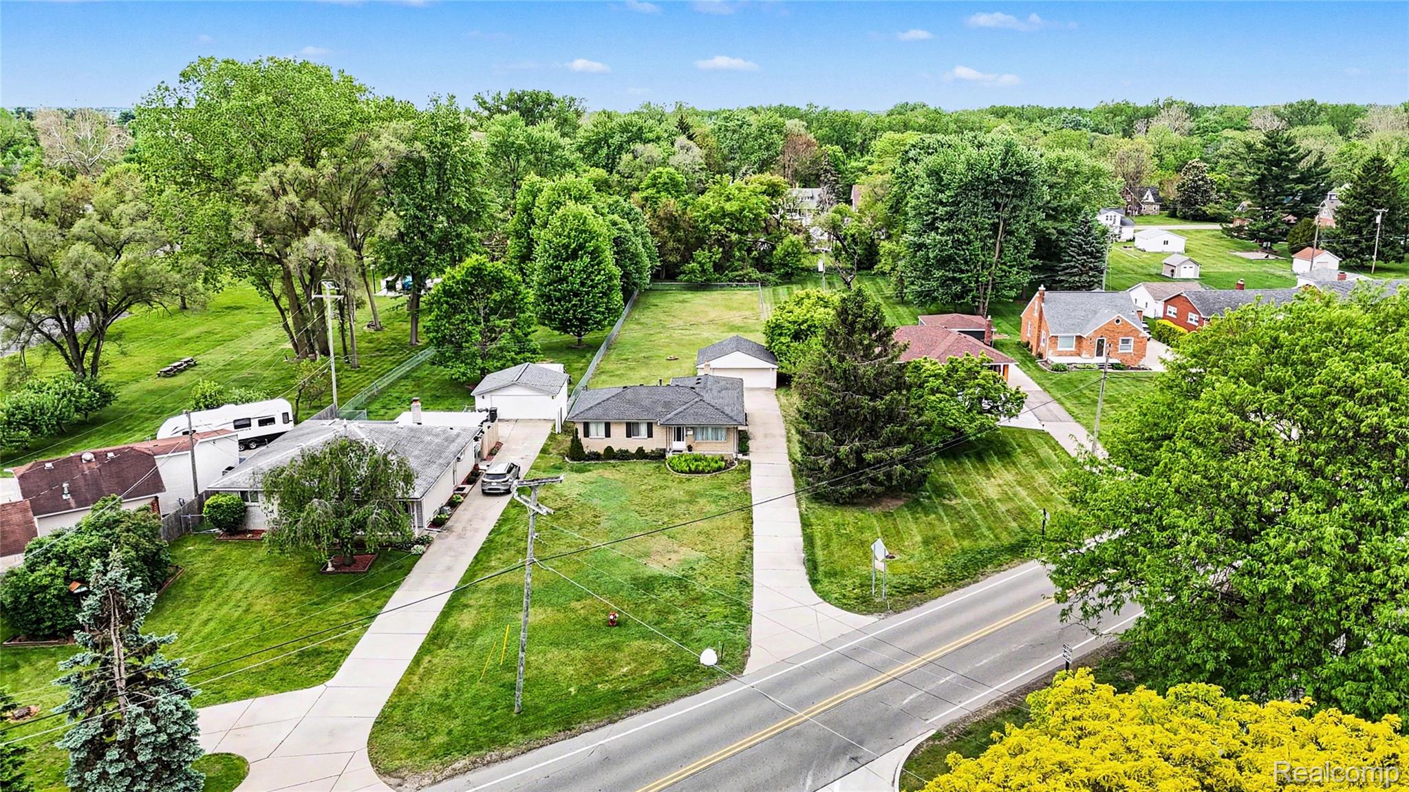 8530 Canal Road Sterling Heights, MI 48314 - Photo 12 of 31 Expansive parcel with a large grassy area, mature trees, and an asphalt road frontage