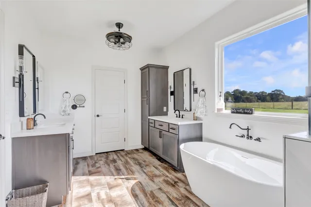 a spacious bathroom with a tub sink and mirror