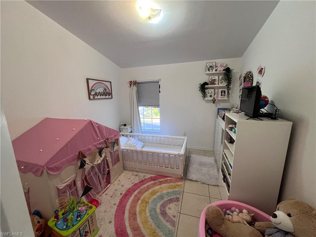 972 Hampton Circle, Unit 77 Naples, FL 34105 - Photo 17 of 24 a bedroom with a bed and a window