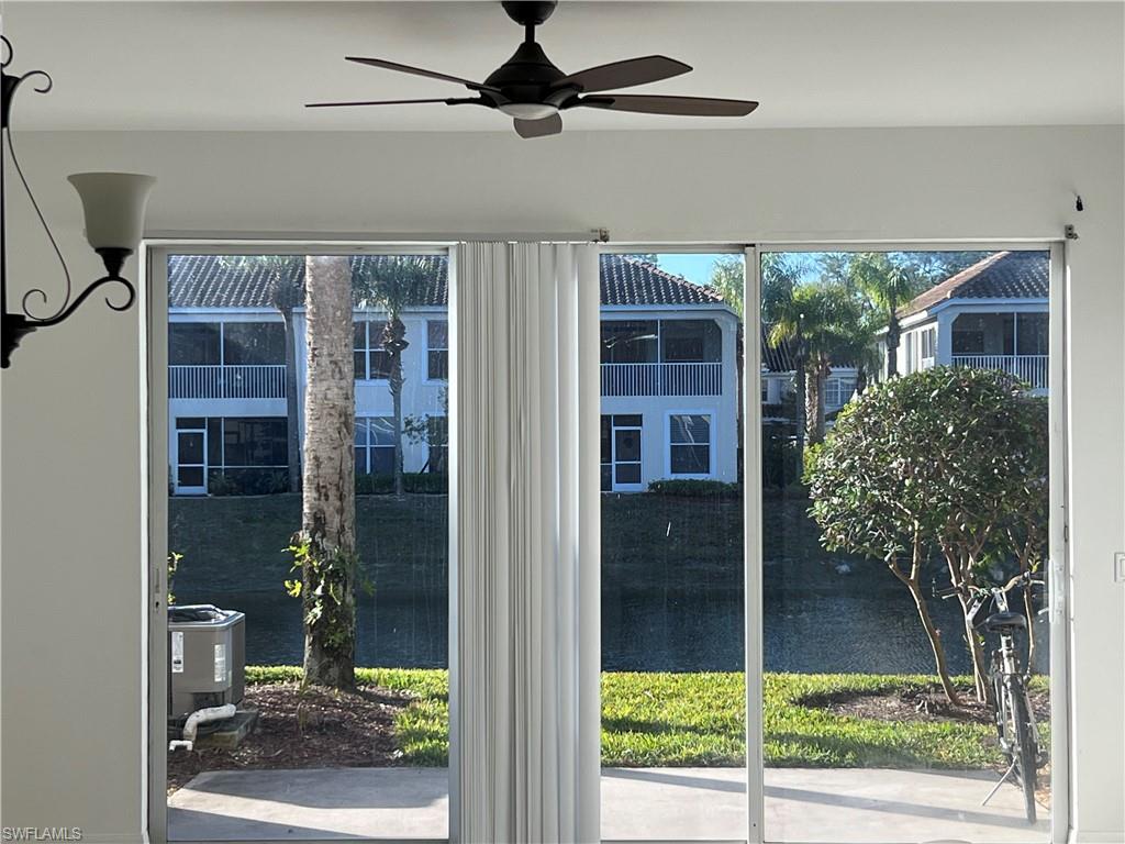 972 Hampton Circle, Unit 77 Naples, FL 34105 - Photo 10 of 24 a view of a porch with a floor to ceiling window and wooden floor