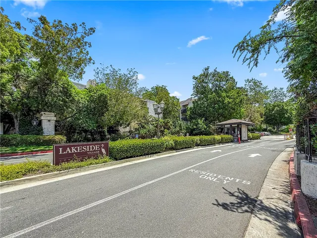 a view of a street with a bench and trees around