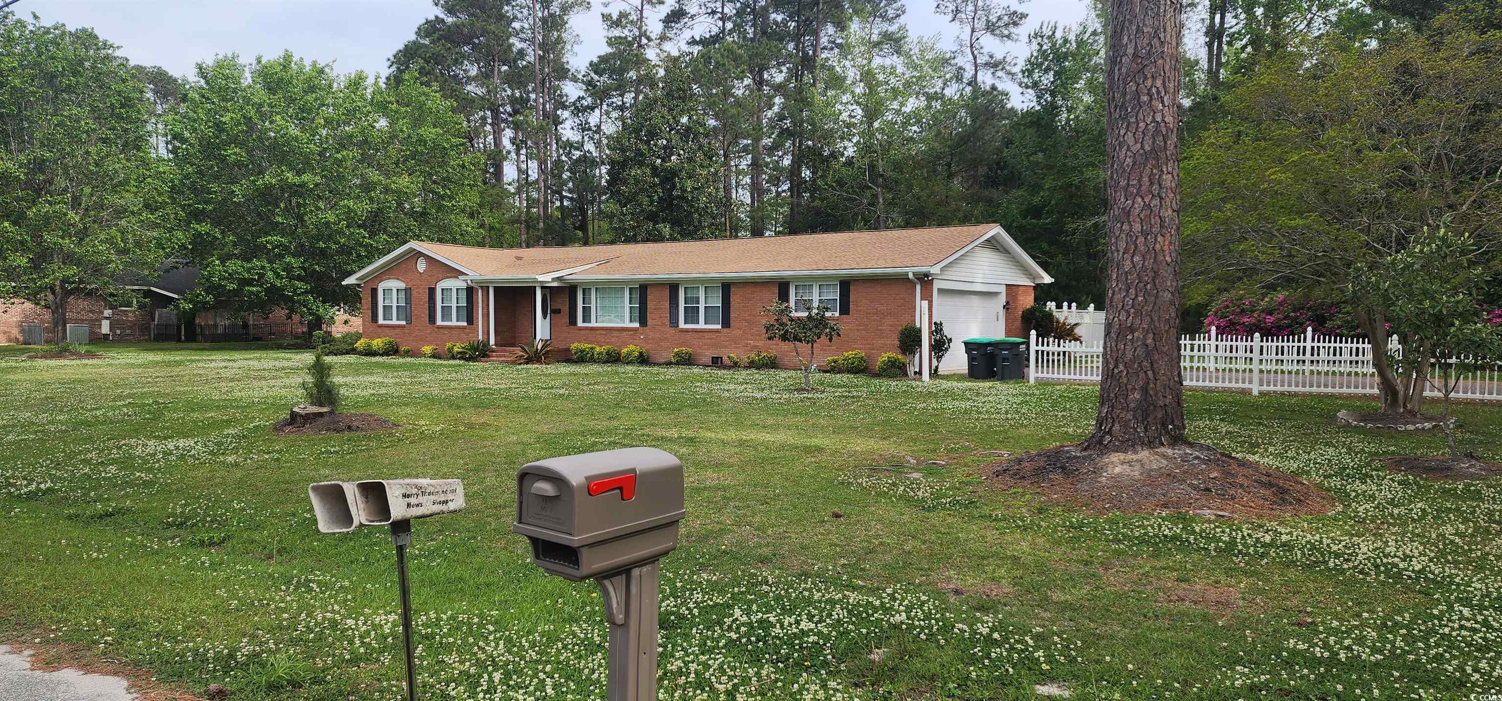 Ranch-style house featuring a garage, a front yard