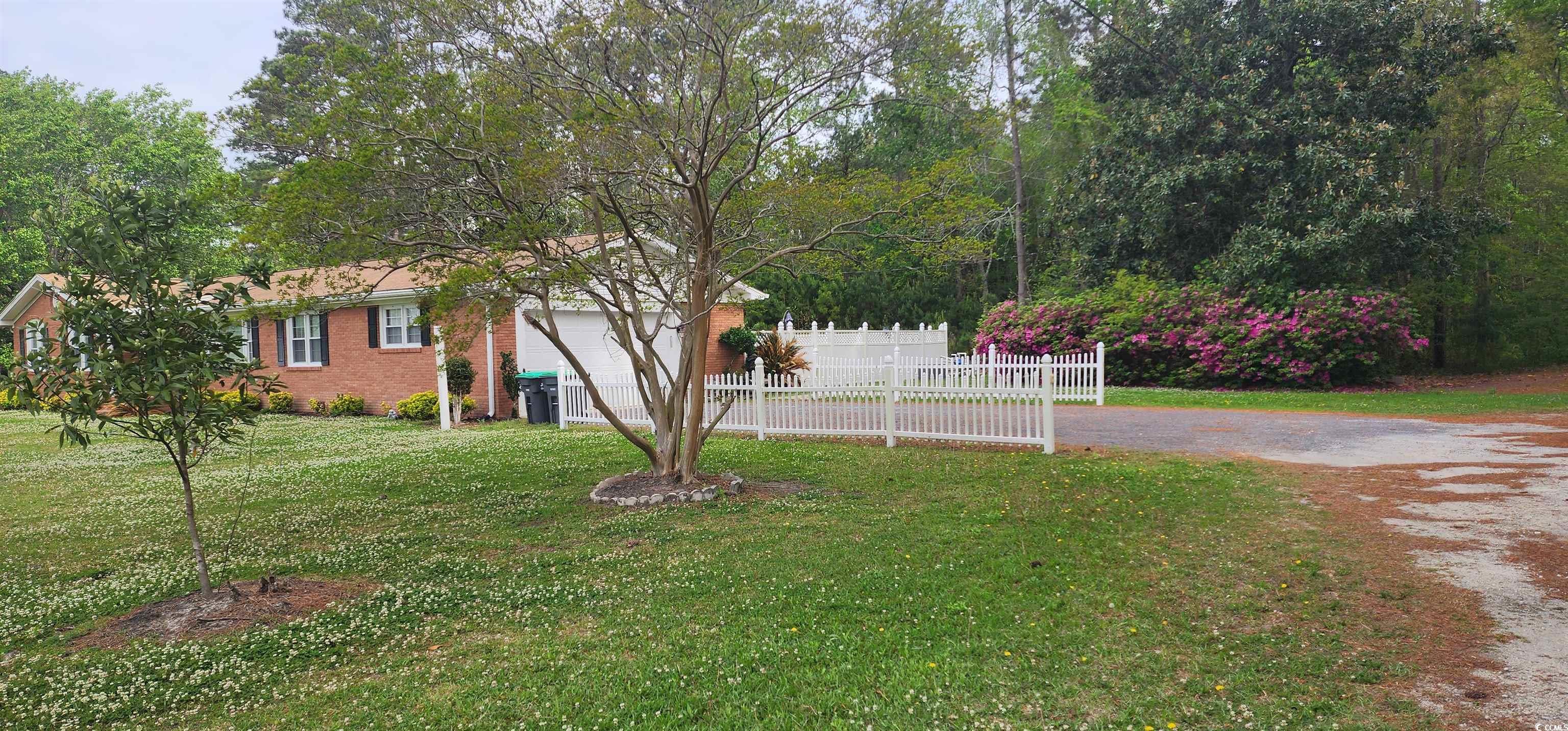 3503 Pinewood Drive Loris, SC 29569 - Photo 2 of 9 View of yard with driveway, a garage, and fence