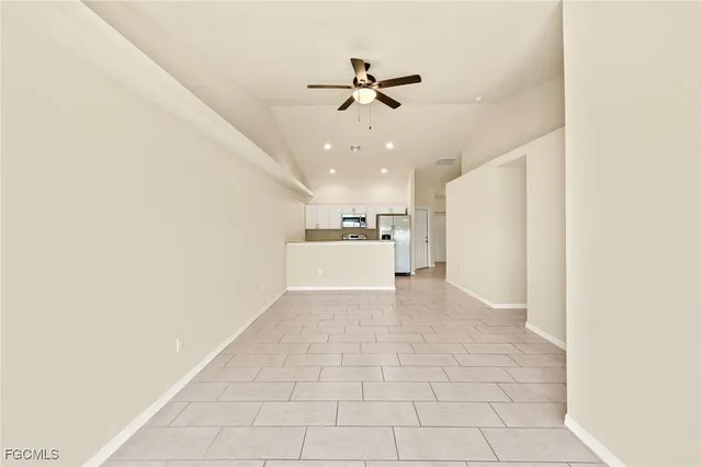 a view of a livingroom with a ceiling fan and kitchen view